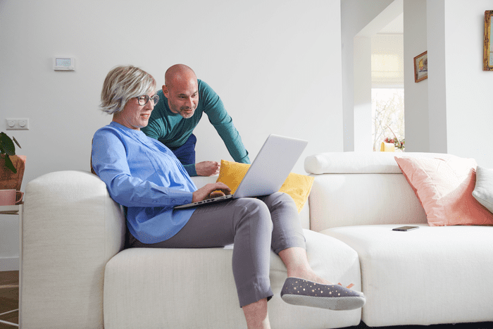 wat is een variabel energiecontract - man en vrouw zitten op een bank kijken op laptop