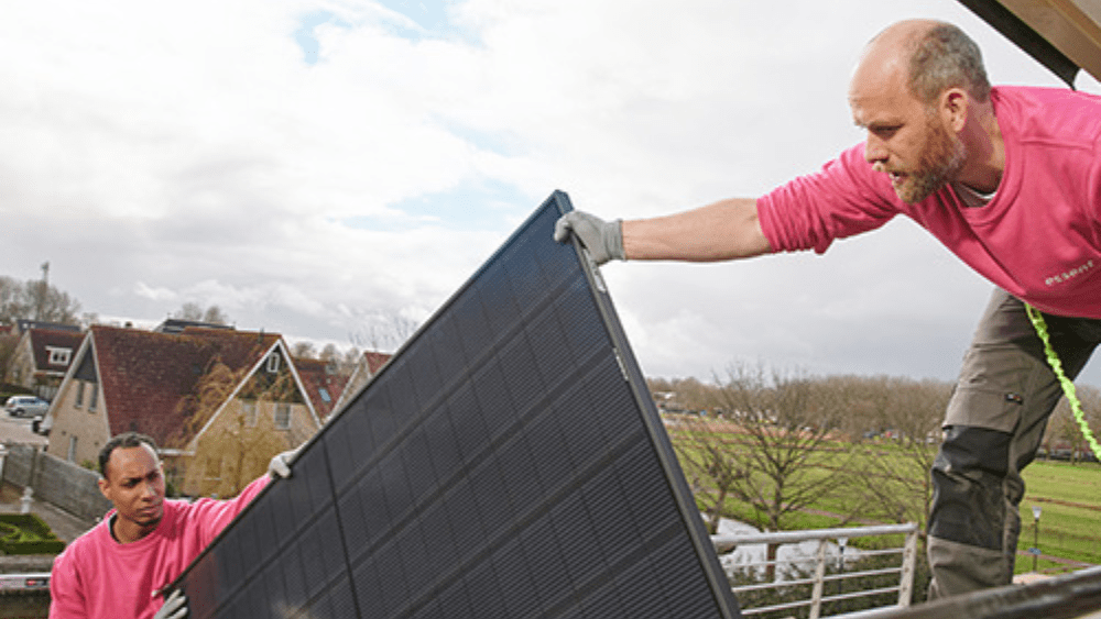 Medewerkers van Essent legt zonnepanelen op een dak om energie te besparen en zelf elektriciteit op te wekken