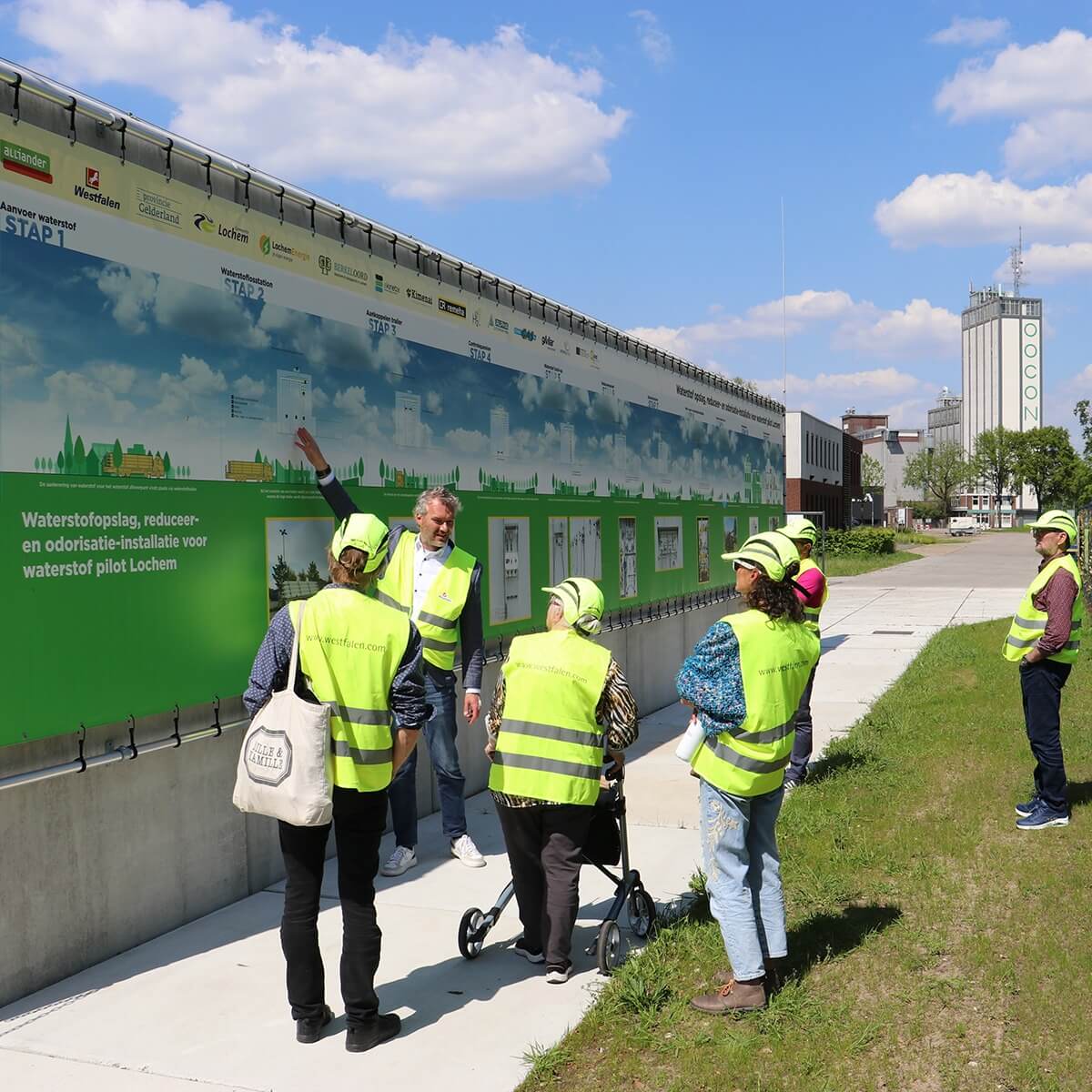 Mensen met geel hesje bij een grote banner van Stad aan ’t Haringvliet